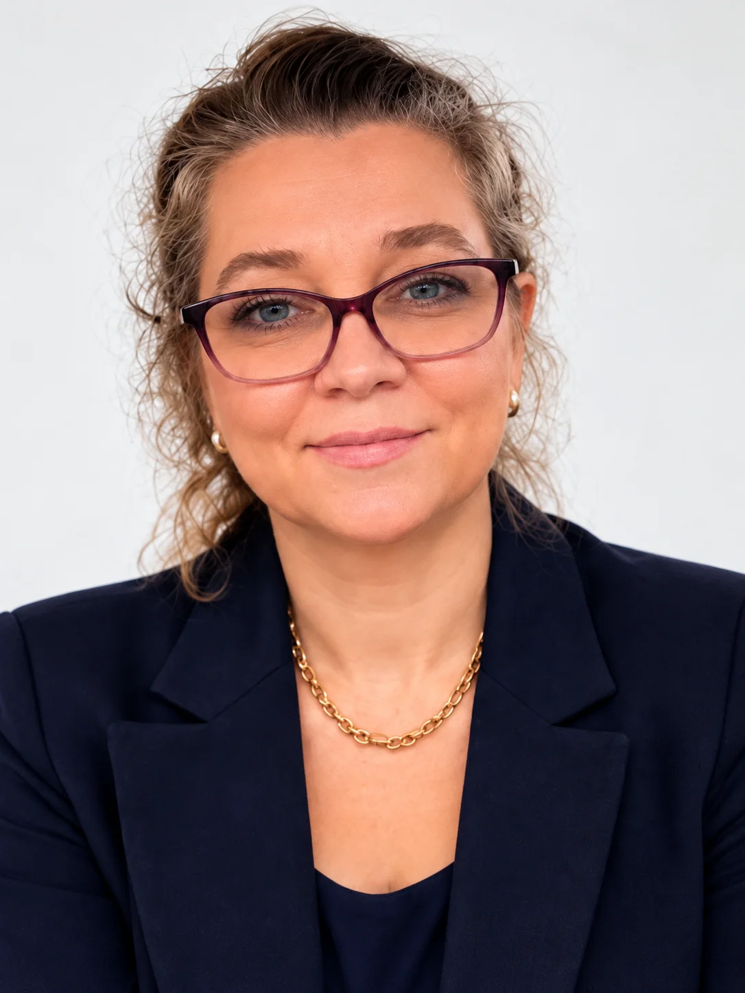 Katya Klopp, a Channel, wearing a navy jacket and glasses